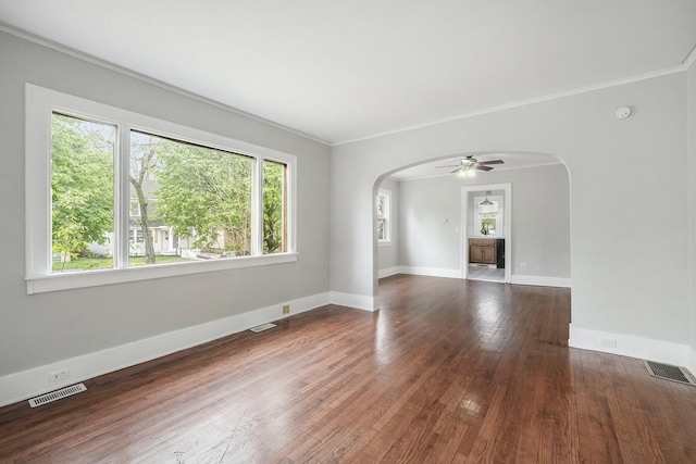 unfurnished room with arched walkways, visible vents, and a ceiling fan