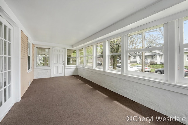 unfurnished sunroom featuring carpet flooring