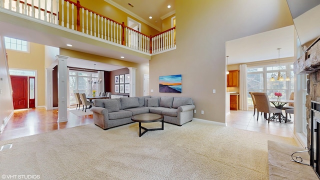7272 Holden Rd, Stevensville, MI 49127 - carpeted living area featuring a chandelier, a high ceiling, baseboards, and decorative columns