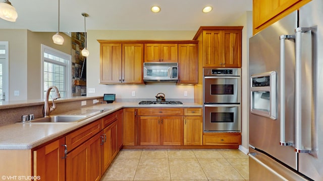 7272 Holden Rd, Stevensville, MI 49127 - kitchen featuring decorative light fixtures, brown cabinetry, a sink, light countertops, and appliances with stainless steel finishes