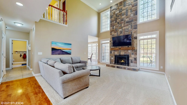 7272 Holden Rd, Stevensville, MI 49127 - carpeted living area featuring a towering ceiling, crown molding, baseboards, and a fireplace