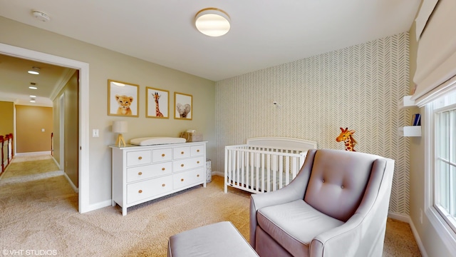 7272 Holden Rd, Stevensville, MI 49127 - bedroom with a crib, wallpapered walls, light carpet, and baseboards