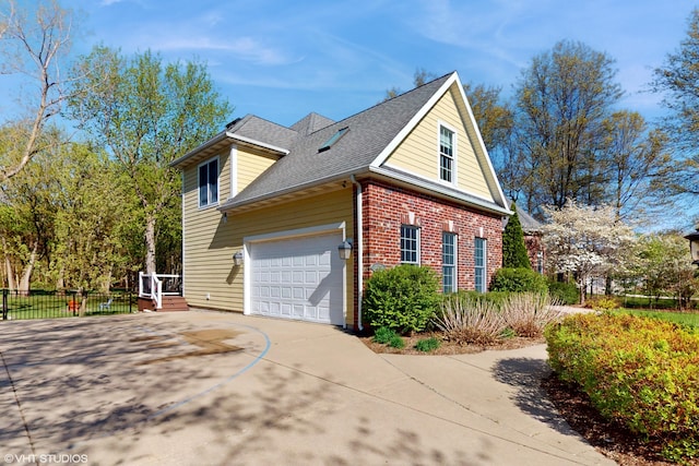 7272 Holden Rd, Stevensville, MI 49127 - view of home's exterior featuring brick siding, fence, a garage, concrete driveway, and roof with shingles