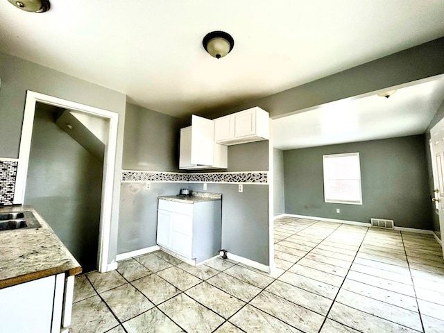 16476 Rossini Dr, Detroit, MI 48205 - kitchen featuring a sink, white cabinets, visible vents, backsplash, and light tile patterned flooring