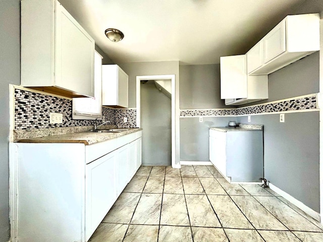 16476 Rossini Dr, Detroit, MI 48205 - kitchen featuring a sink, backsplash, and white cabinets
