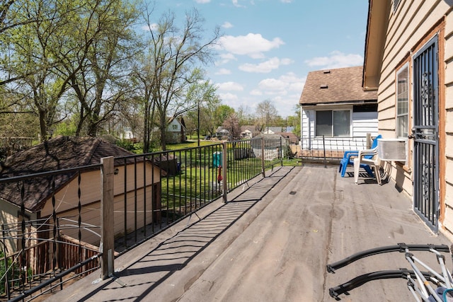wooden terrace featuring a yard and fence