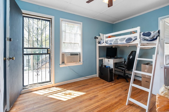 bedroom featuring baseboards, cooling unit, crown molding, and wood finished floors