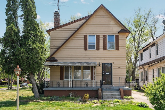 view of front of property with a front lawn, a porch, and a chimney
