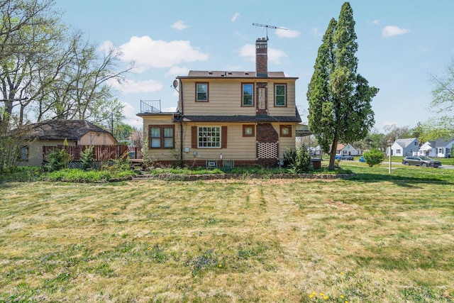 back of house with a wooden deck, a chimney, and a lawn
