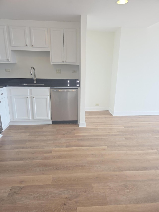 3320 Spinnaker Ln Unit 15E, Detroit, MI 48207 - kitchen with stainless steel dishwasher, a sink, dark countertops, and white cabinetry