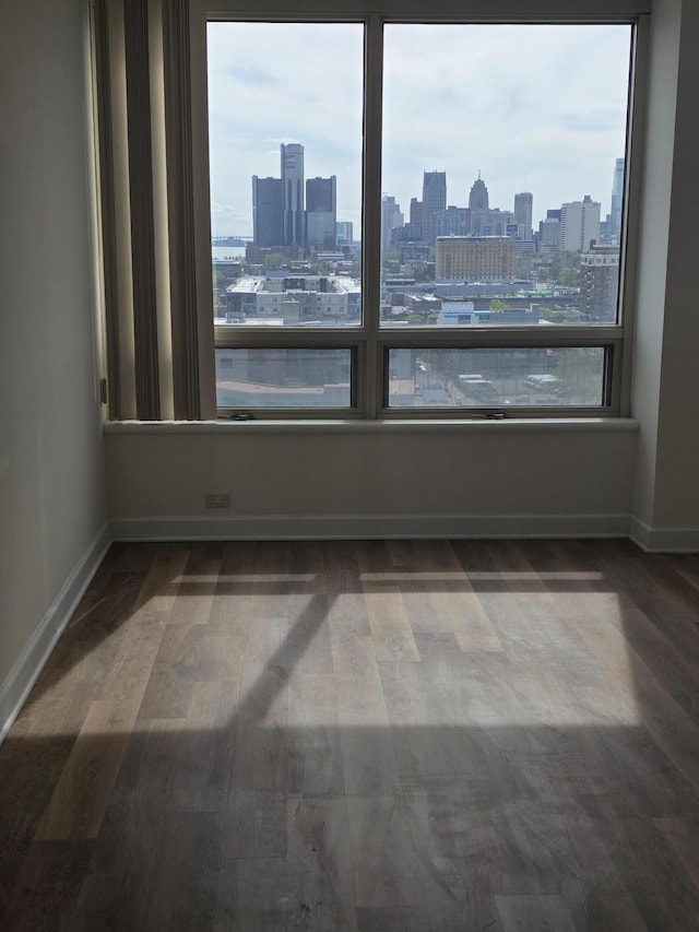 3320 Spinnaker Ln Unit 15E, Detroit, MI 48207 - spare room with a skyline view, wood finished floors, and baseboards