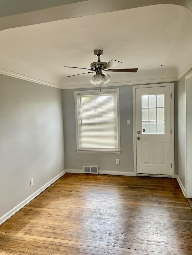 entryway featuring ceiling fan, wood-type flooring, baseboards, and ornamental molding