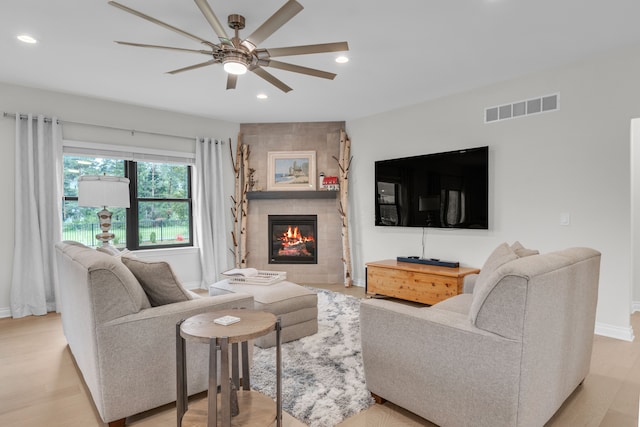 3166 Roma, Wixom, MI 48393 - living room with a ceiling fan, recessed lighting, a tiled fireplace, baseboards, and light wood-style floors