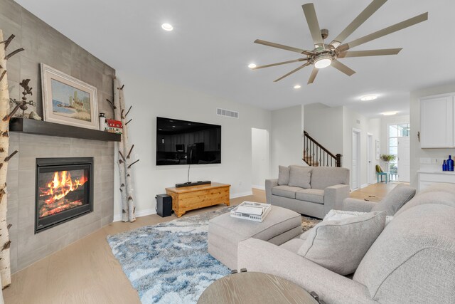 3166 Roma, Wixom, MI 48393 - living area featuring wood finished floors, a tile fireplace, ceiling fan, recessed lighting, and stairway