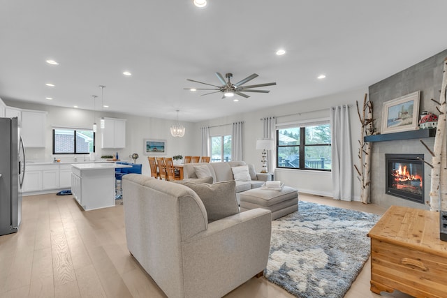 3166 Roma, Wixom, MI 48393 - living area with recessed lighting, a fireplace, ceiling fan, light wood-style flooring, and a chandelier