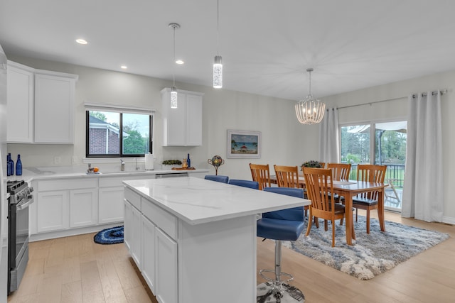 3166 Roma, Wixom, MI 48393 - kitchen with gas range, a center island, light wood-type flooring, plenty of natural light, and recessed lighting