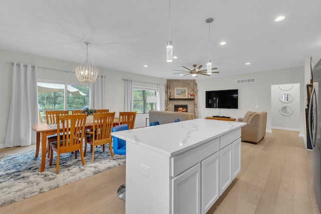 3166 Roma, Wixom, MI 48393 - kitchen featuring light wood-type flooring, a fireplace, white cabinetry, a ceiling fan, and recessed lighting