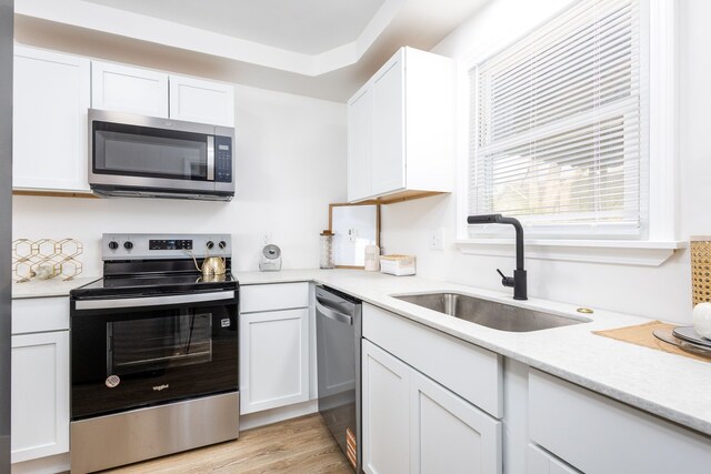 21430 Ridgedale St, Oak Park, MI 48237 - kitchen featuring white cabinets, light countertops, stainless steel appliances, and a sink