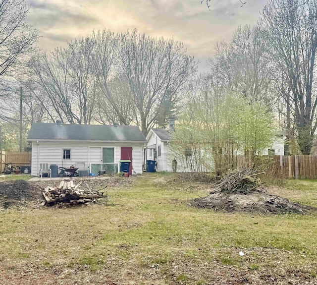 back of property with fence and a lawn