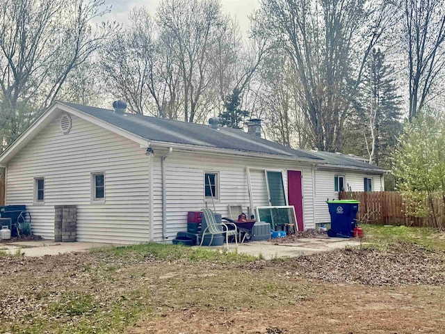 back of house featuring fence and a chimney