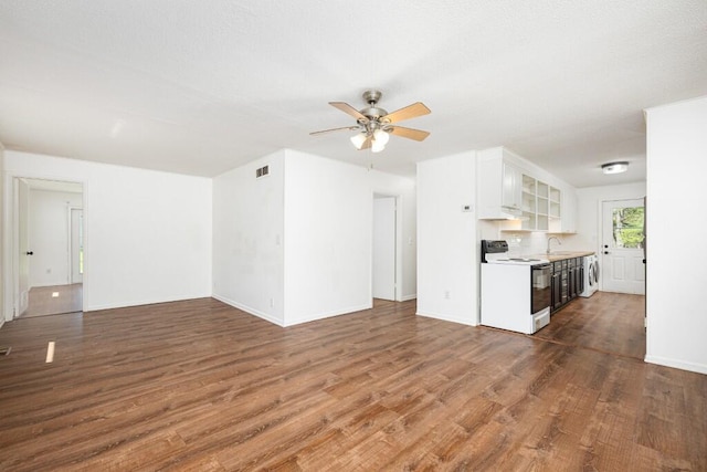 unfurnished living room featuring visible vents, baseboards, a ceiling fan, and dark wood-style floors