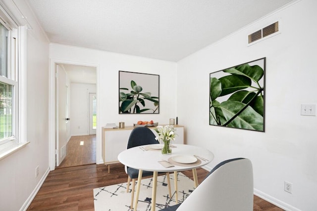 dining room with visible vents, baseboards, and dark wood-type flooring