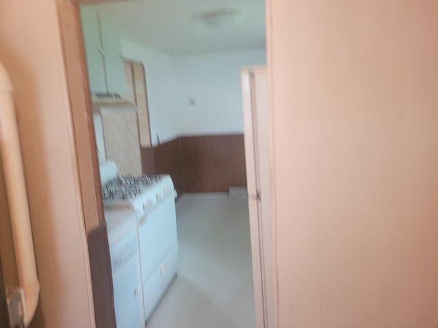 corridor featuring wainscoting and washer / dryer