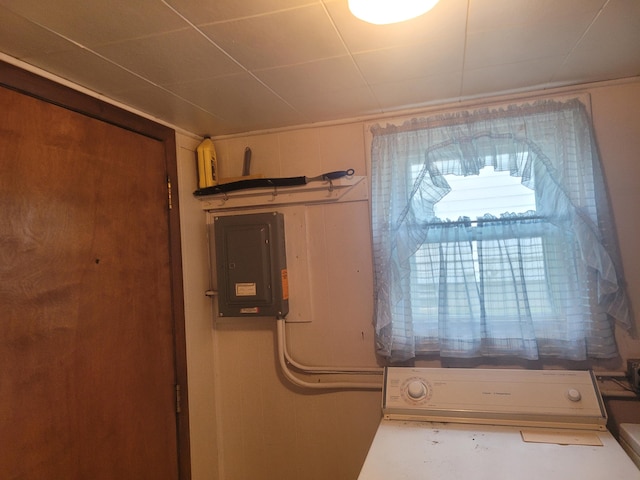 utility room with electric panel and washer / dryer
