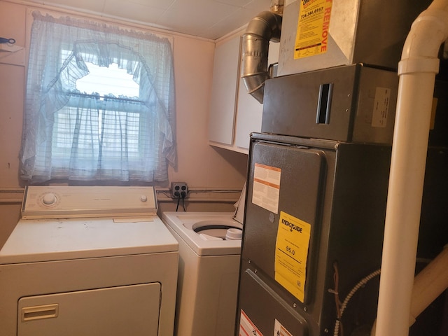 washroom featuring heating unit and washer and dryer