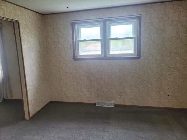 carpeted spare room featuring baseboards and wallpapered walls