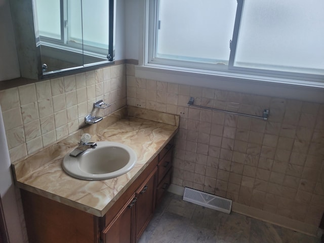 bathroom featuring vanity, tile walls, and visible vents