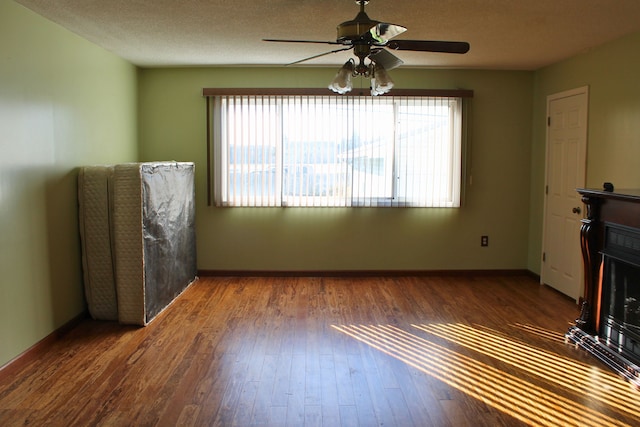 unfurnished living room featuring ceiling fan, healthy amount of natural light, and hardwood / wood-style flooring