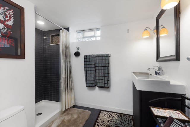 bathroom with toilet, vanity, recessed lighting, baseboards, and a tile shower