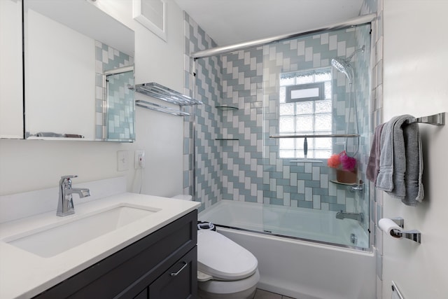 bathroom with toilet, bath / shower combo with glass door, and vanity