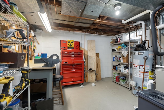 unfinished below grade area featuring water heater and concrete block wall