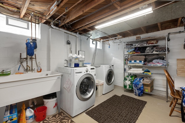 laundry area featuring washing machine and clothes dryer, plenty of natural light, and concrete block wall