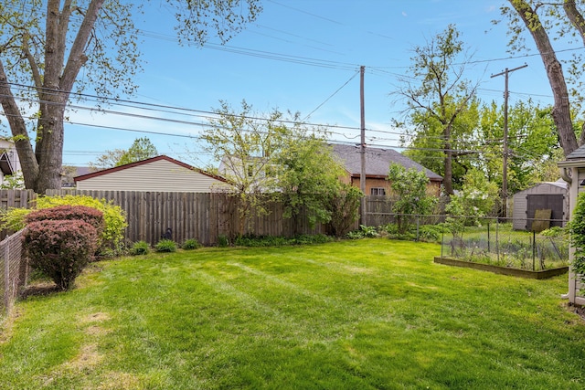 view of yard with a vegetable garden, a storage unit, and an outdoor structure