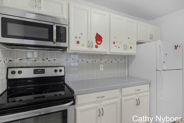 kitchen with appliances with stainless steel finishes, white cabinetry, light countertops, and decorative backsplash