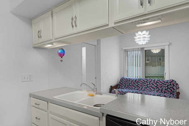 kitchen with a sink, white cabinetry, and light countertops