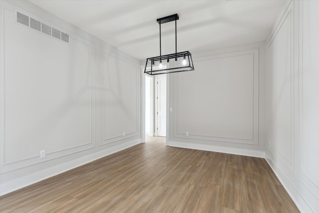 45518 Jefferson Ave, Chesterfield, MI 48047 - unfurnished dining area with a chandelier, wood finished floors, and a decorative wall