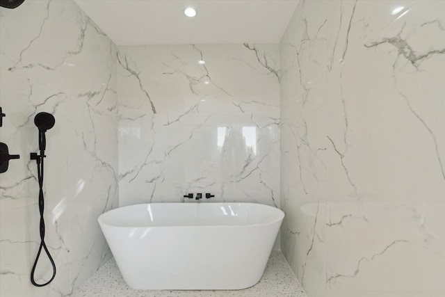 45518 Jefferson Ave, Chesterfield, MI 48047 - bathroom with a soaking tub, speckled floor, recessed lighting, and stone wall