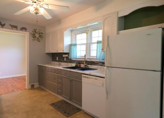kitchen with white appliances, a sink, decorative backsplash, ceiling fan, and light countertops