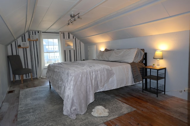 bedroom with vaulted ceiling and wood finished floors