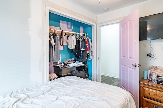 bedroom with wood finished floors and a closet