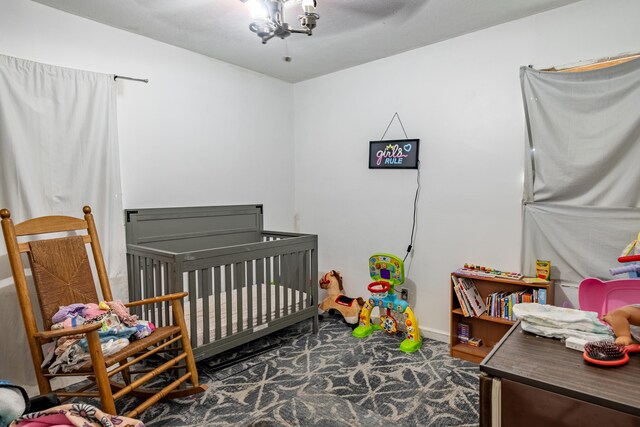 carpeted bedroom with baseboards and a crib