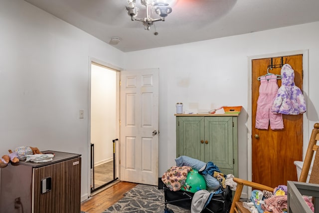 bedroom with wood finished floors and a chandelier