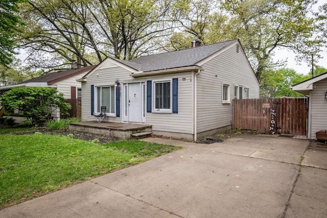 view of front of home with roof with shingles and driveway