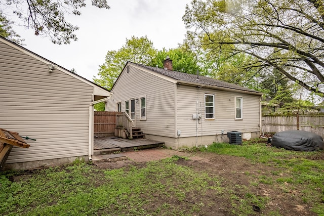 rear view of house featuring fence, a chimney, central air condition unit, and a deck