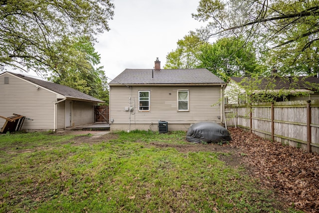 rear view of property featuring central AC unit and a chimney