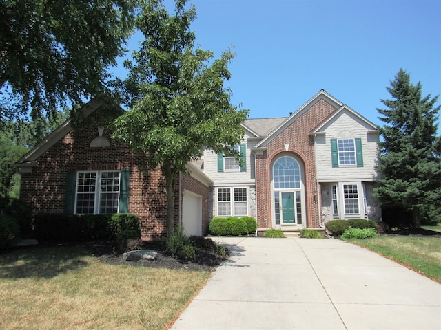 traditional-style home featuring a front yard, an attached garage, brick siding, and driveway